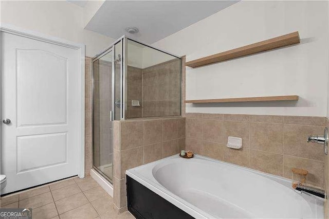 full bathroom with tile patterned flooring, a shower stall, a bath, and toilet