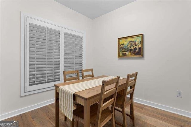 dining space with dark wood-type flooring and baseboards