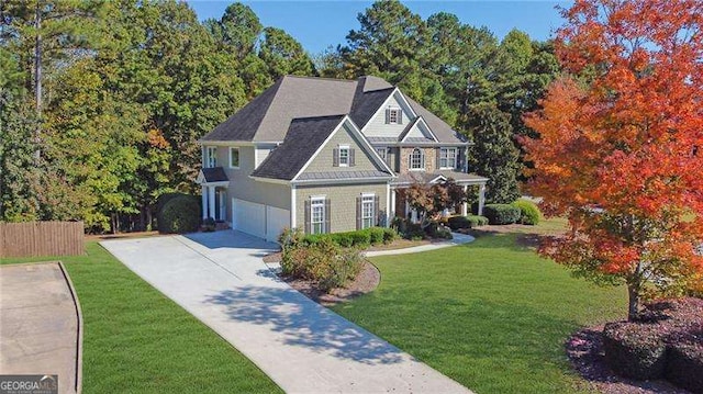 craftsman-style house with a front yard, fence, a garage, and driveway