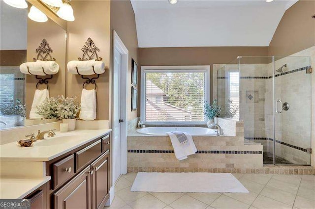 bathroom featuring tile patterned flooring, a shower stall, a garden tub, vaulted ceiling, and vanity