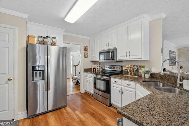 kitchen with a sink, white cabinets, and stainless steel appliances