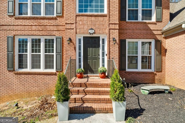 doorway to property featuring brick siding