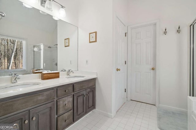 full bath with tile patterned floors, a stall shower, double vanity, and a sink