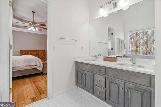 ensuite bathroom with crown molding, ensuite bathroom, ceiling fan, and a sink