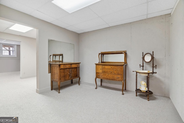 interior space featuring a paneled ceiling and carpet