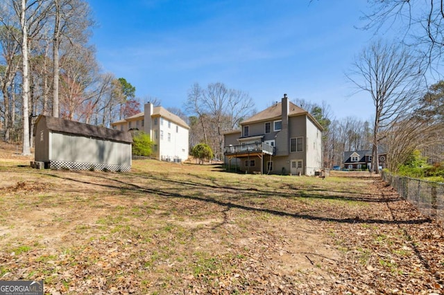 view of yard featuring a deck, an outdoor structure, and a storage unit