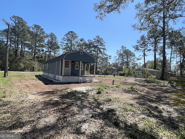 exterior space with a gambrel roof and an outdoor structure