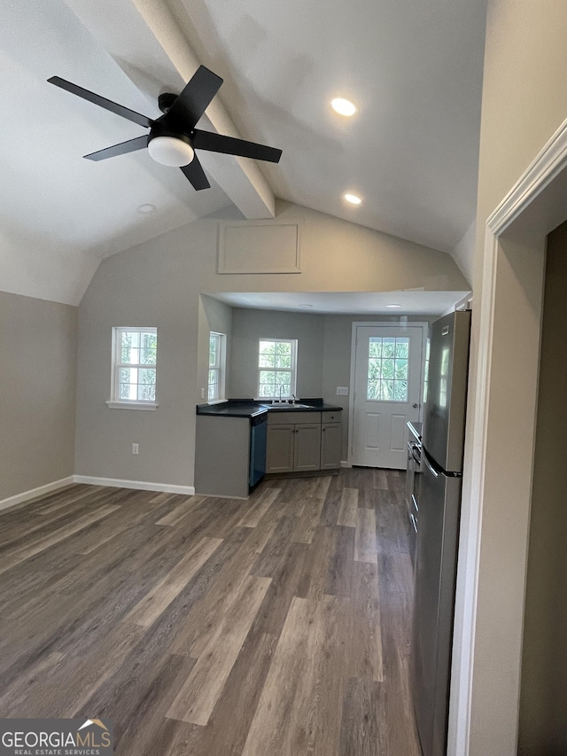 kitchen featuring dark wood-style flooring, dark countertops, freestanding refrigerator, dishwasher, and vaulted ceiling with beams