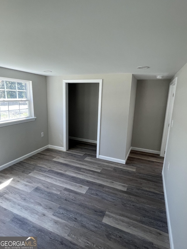 unfurnished room featuring dark wood-style floors and baseboards