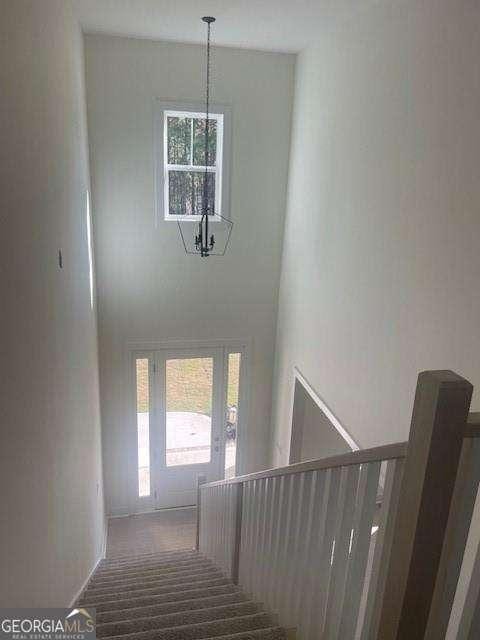 stairway featuring a chandelier and a high ceiling