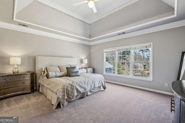 carpeted bedroom with visible vents, baseboards, a tray ceiling, and ornamental molding