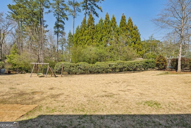 view of yard featuring fence and a playground