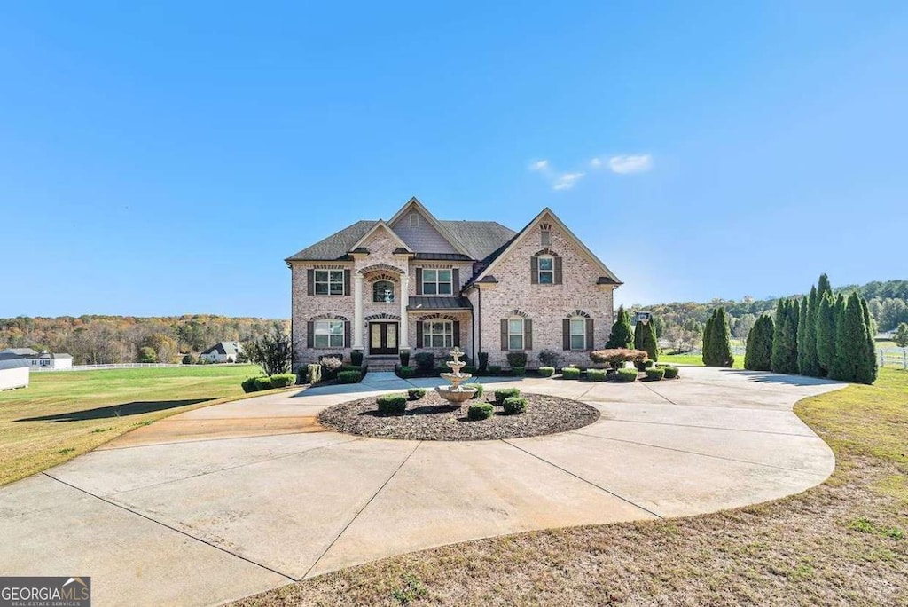 view of front facade with a front lawn and curved driveway