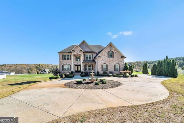 view of front facade with a front lawn and curved driveway