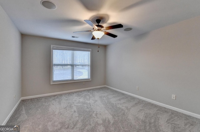 spare room featuring carpet flooring, a ceiling fan, baseboards, and visible vents