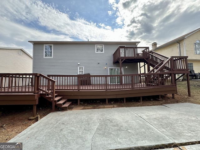 back of property featuring stairs, a patio, and a deck