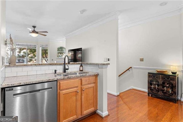 kitchen featuring a sink, light stone countertops, crown molding, and stainless steel dishwasher