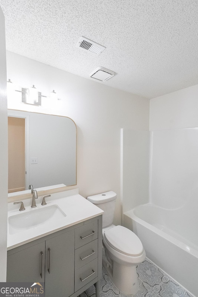 bathroom featuring visible vents, toilet, shower / bath combination, vanity, and a textured ceiling