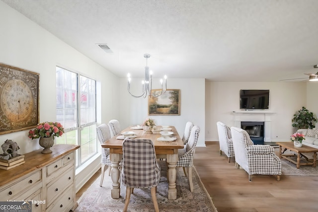 dining space with a chandelier, visible vents, a healthy amount of sunlight, and light wood-type flooring