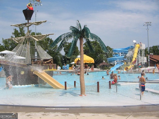 view of swimming pool featuring a water slide and a water play area