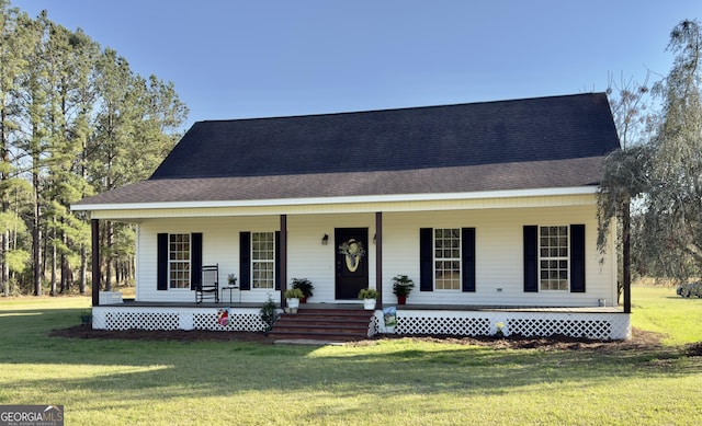 view of front of property featuring a porch, a shingled roof, and a front yard