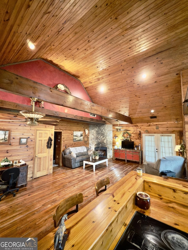 living room featuring a fireplace, hardwood / wood-style flooring, wood ceiling, and wood walls