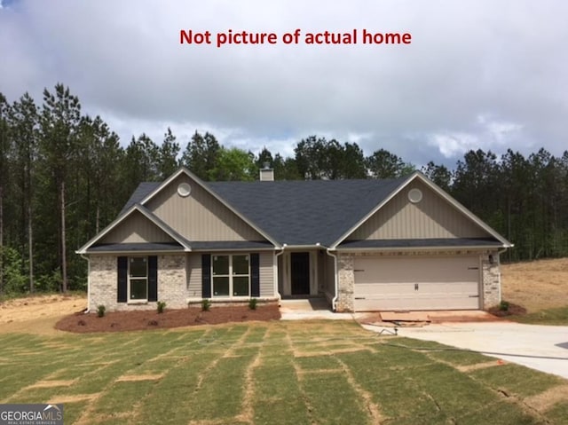 craftsman house featuring concrete driveway, an attached garage, brick siding, and a front yard