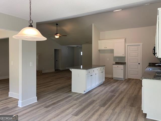 kitchen featuring open floor plan, white cabinetry, and a ceiling fan