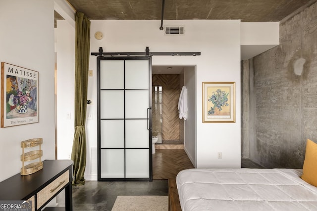 bedroom featuring a barn door, visible vents, and finished concrete floors