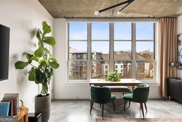 dining area with baseboards, concrete floors, and radiator heating unit