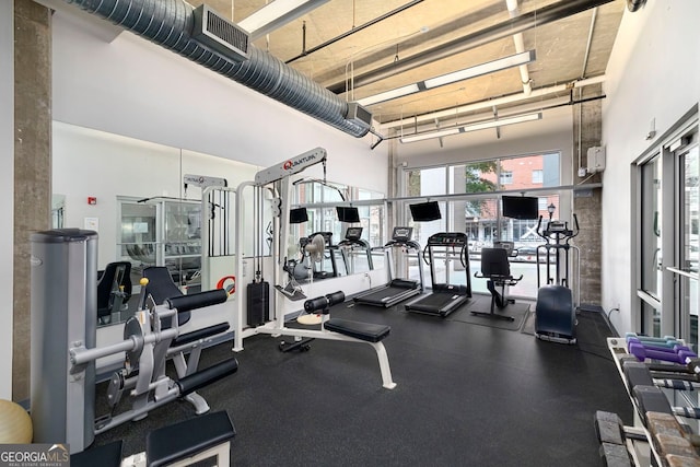 workout area featuring a towering ceiling