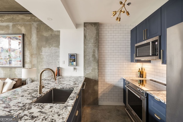 kitchen with light stone counters, concrete floors, a sink, appliances with stainless steel finishes, and blue cabinets