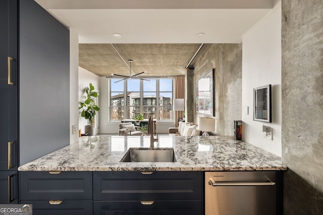 kitchen with a sink, light stone counters, and open floor plan