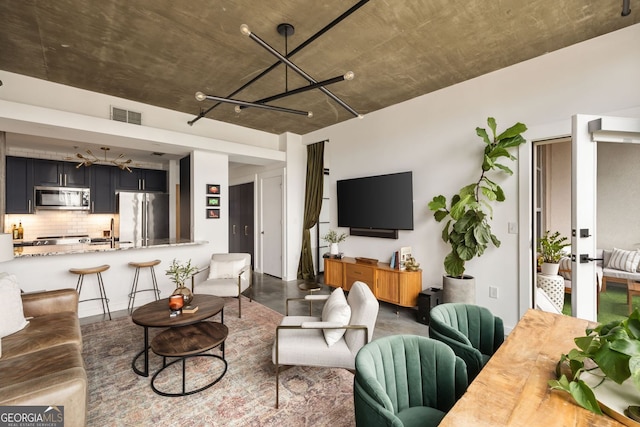 living area featuring a notable chandelier, visible vents, and finished concrete flooring