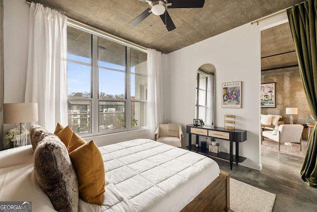 bedroom featuring ceiling fan and finished concrete floors