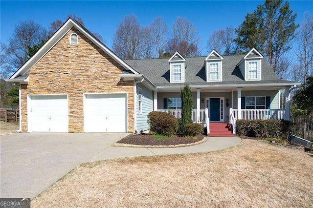 view of front of home with a porch, concrete driveway, stone siding, and an attached garage