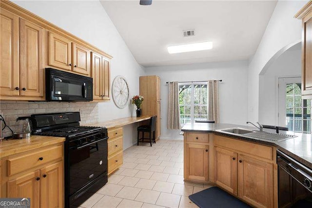 kitchen featuring tasteful backsplash, light tile patterned floors, arched walkways, black appliances, and a sink