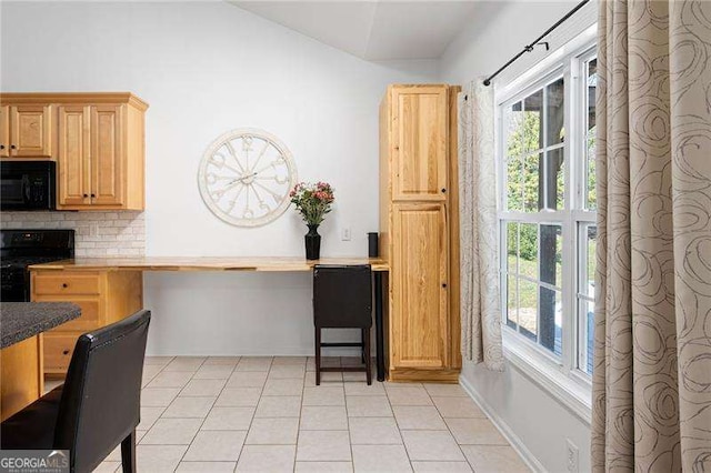 kitchen featuring backsplash, light brown cabinets, baseboards, light tile patterned floors, and black appliances