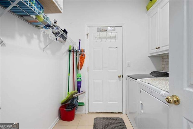 washroom with cabinet space, light tile patterned floors, and washing machine and dryer