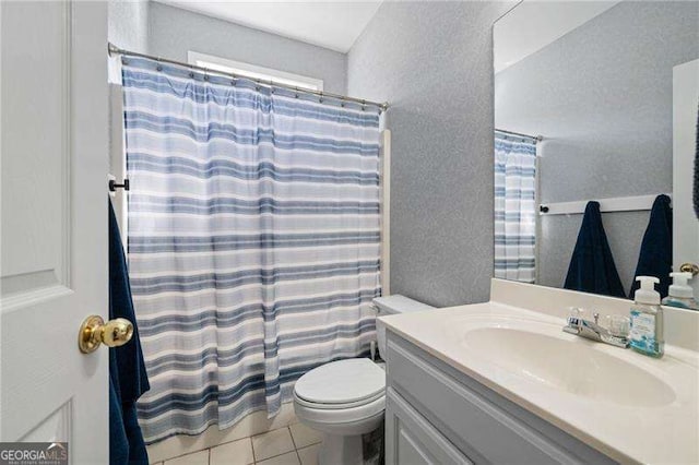 full bathroom featuring tile patterned flooring, toilet, a shower with curtain, a textured wall, and vanity