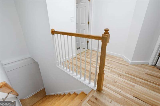 stairway featuring baseboards and wood finished floors