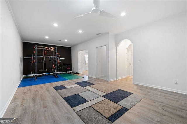 workout room featuring a ceiling fan, wood finished floors, baseboards, recessed lighting, and arched walkways