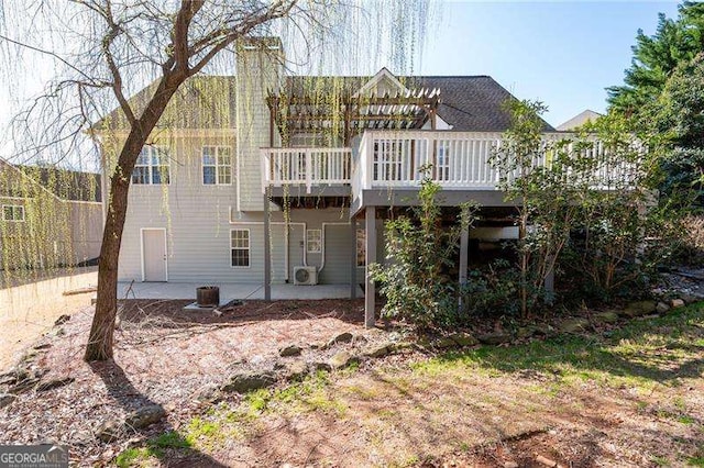 back of property featuring a patio area, a chimney, and a deck