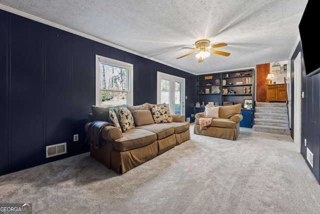 living room with visible vents, crown molding, carpet, stairs, and a textured ceiling