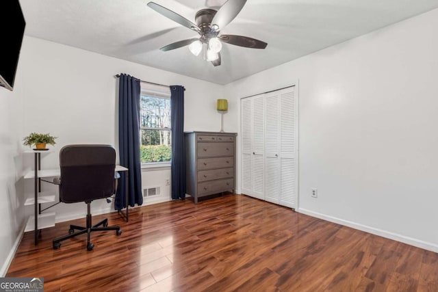 home office featuring visible vents, a ceiling fan, baseboards, and wood finished floors