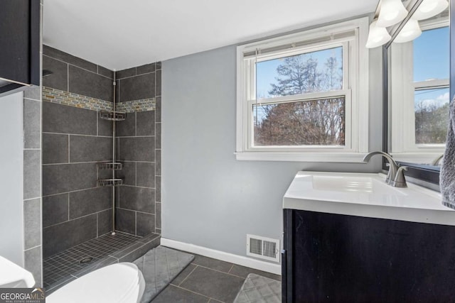 full bath featuring visible vents, baseboards, toilet, tiled shower, and vanity