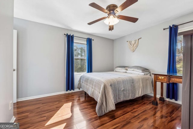 bedroom featuring baseboards, wood finished floors, and a ceiling fan