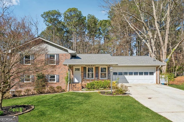 tri-level home with a front lawn, a porch, concrete driveway, an attached garage, and brick siding