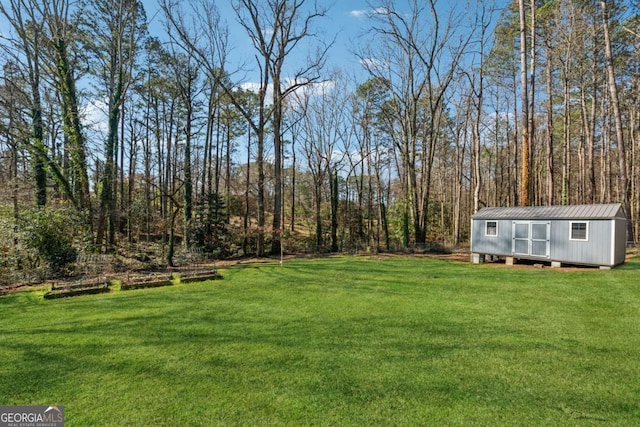 view of yard featuring an outbuilding, a shed, and a wooded view