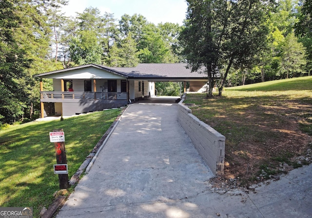 single story home with a front yard, a carport, and driveway